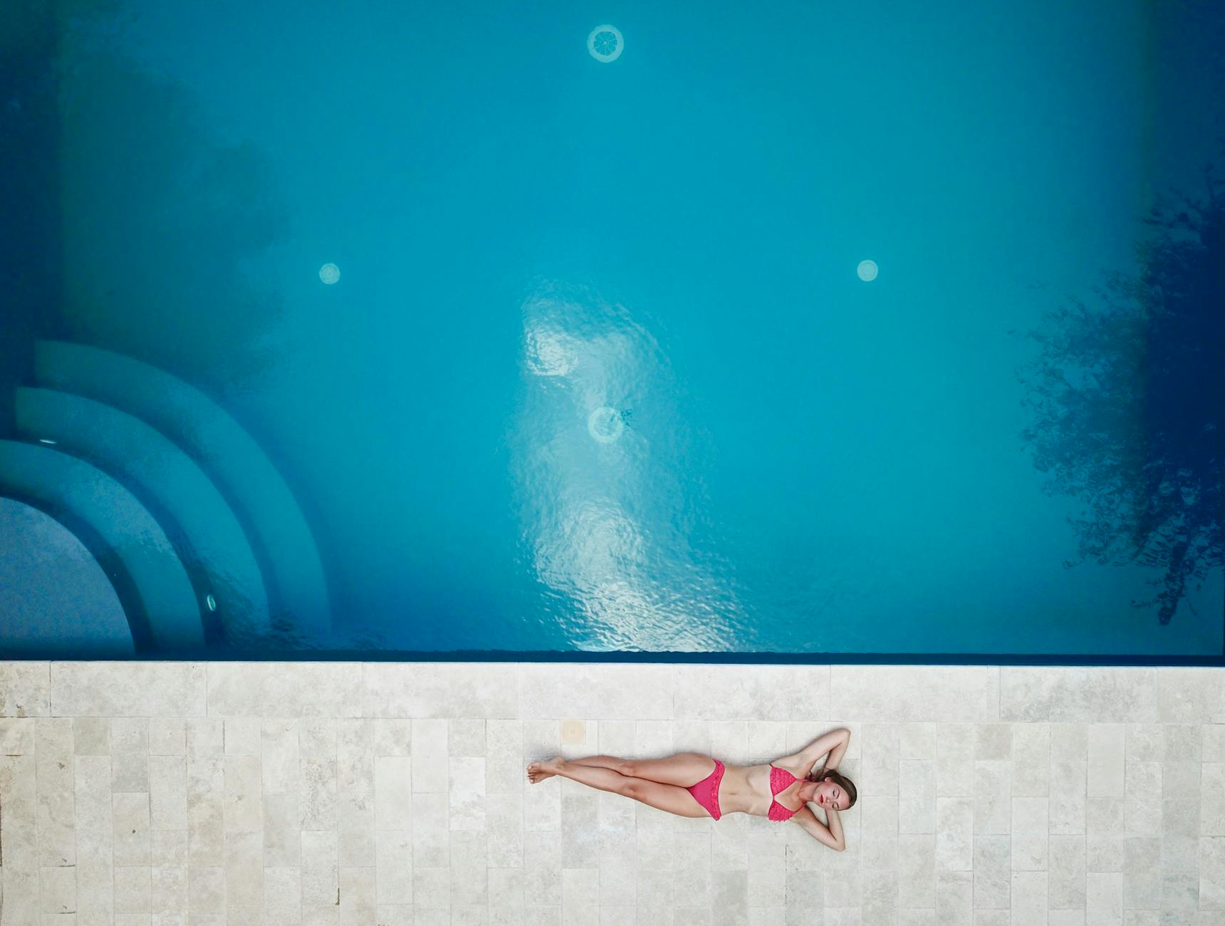 Frau, Die Auf Boden Nahe Pool Liegt